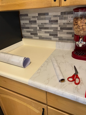 reviewer photo of half a countertop without the cover and the other half with it as it's being applied