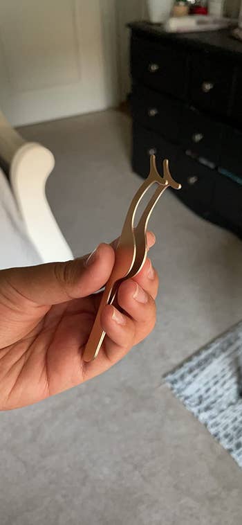 reviewer holding the applicator in gold