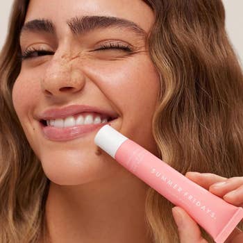 Model holding a tube of Pink Sugar Summer Fridays lip butter balm