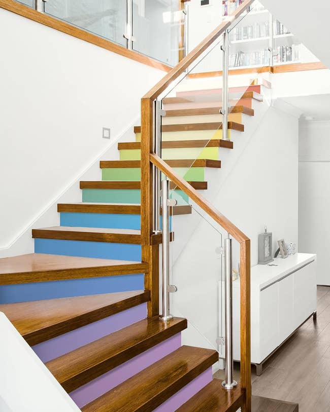 A set of stairs decorated with different soiled color paint decals under each step 