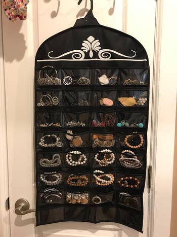one side of reviewer's jewelry organizer with compartments full of bracelets, earrings, etc.
