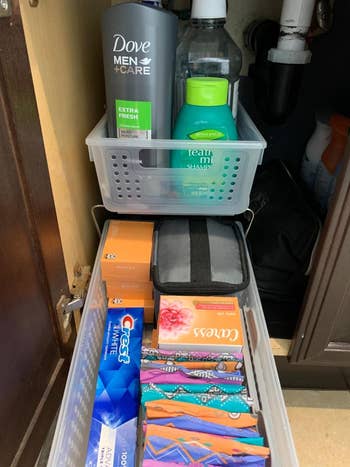 reviewer's toiletries and personal care products organized in the two-tier basket with one pulled out
