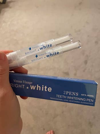 reviewer holding the 2  teeth whitening pens