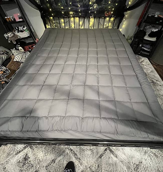 gray quilted mattress cover on reviewer's bed