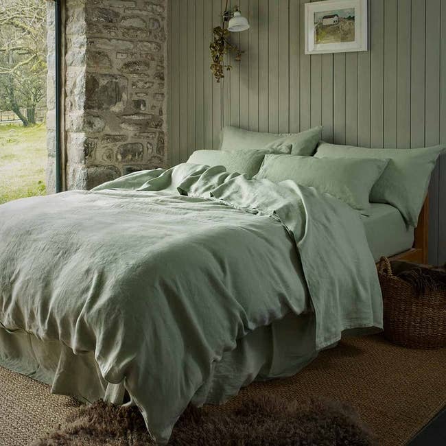 A neatly made bed with green bedding in a cozy bedroom setting