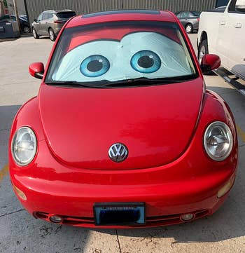 Red Volkswagen Beetle with large cartoon eyes on the windshield