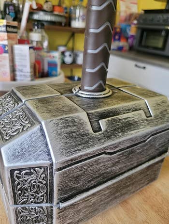 Replica of Thor's hammer, Mjolnir, emerging from patterned box on a counter