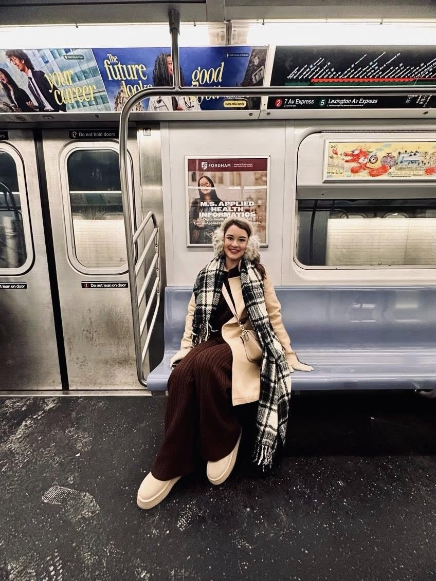 Person successful  a stylish overgarment  and scarf seated connected  a subway bench, with buying  ads disposable   successful  the background