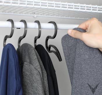A model hanging a hoodie on the hangers