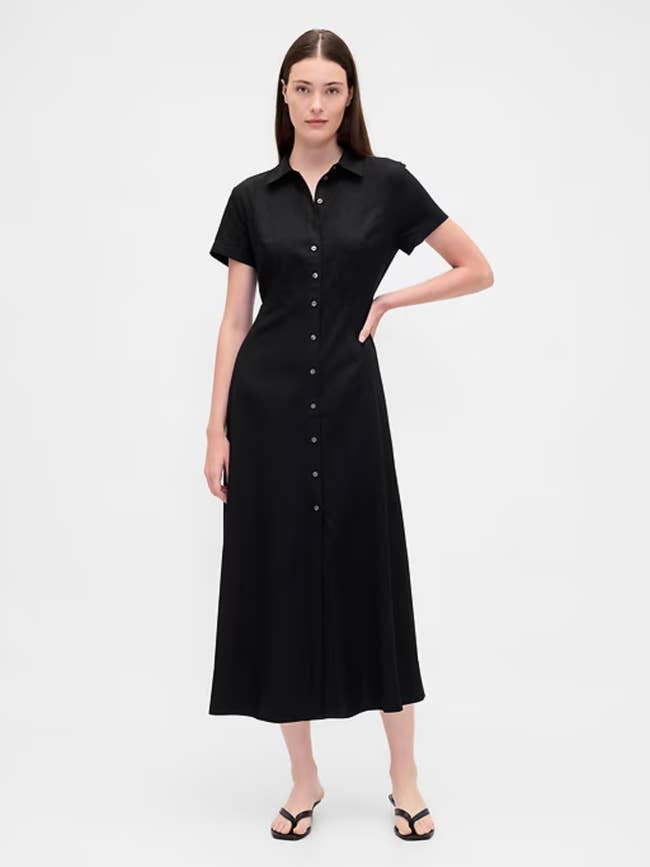 Model wearing a button-up, short-sleeve, agelong achromatic formal with sandals, lasting confidently