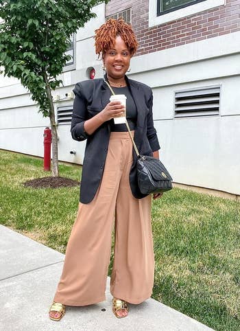 reviewer wearing the camel plaid pants with a black top and blazer