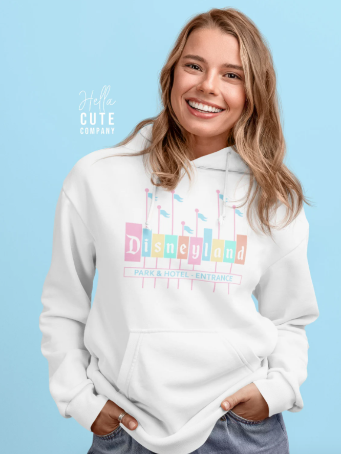 a model in a white sweatshirt with the disneyland logo in pastels