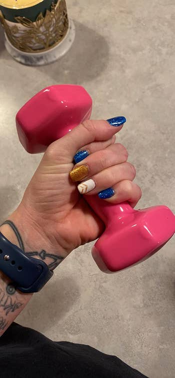 reviewer lifting pink vinyl coated dumbbell