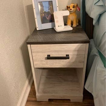 gray wash wooden nightstand next to reviewer's bed