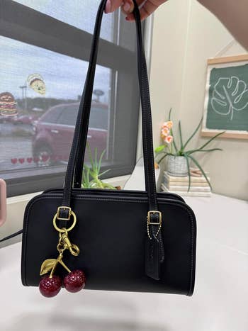 the cherry keychain attached to a black bag