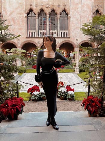 Person successful  a sleek, long-sleeved formal  stands successful  an elegant plot  setting, accessorized with a waist concatenation  and fur accents connected  sleeves and boots