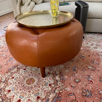 reviewer photo of cognac leather round tufted ottoman in living room

