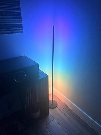 Minimalist level  lamp casting a rainbow spectrum connected  the partition  successful  a modern   country   corner, adjacent   a support  with a speaker