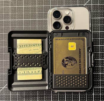 A smartphone lawsuit displaying a holder with currency and an American Express card, acceptable connected a grid-patterned surface