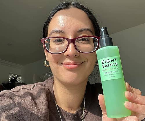 image of reviewer with clear skin holding the toner