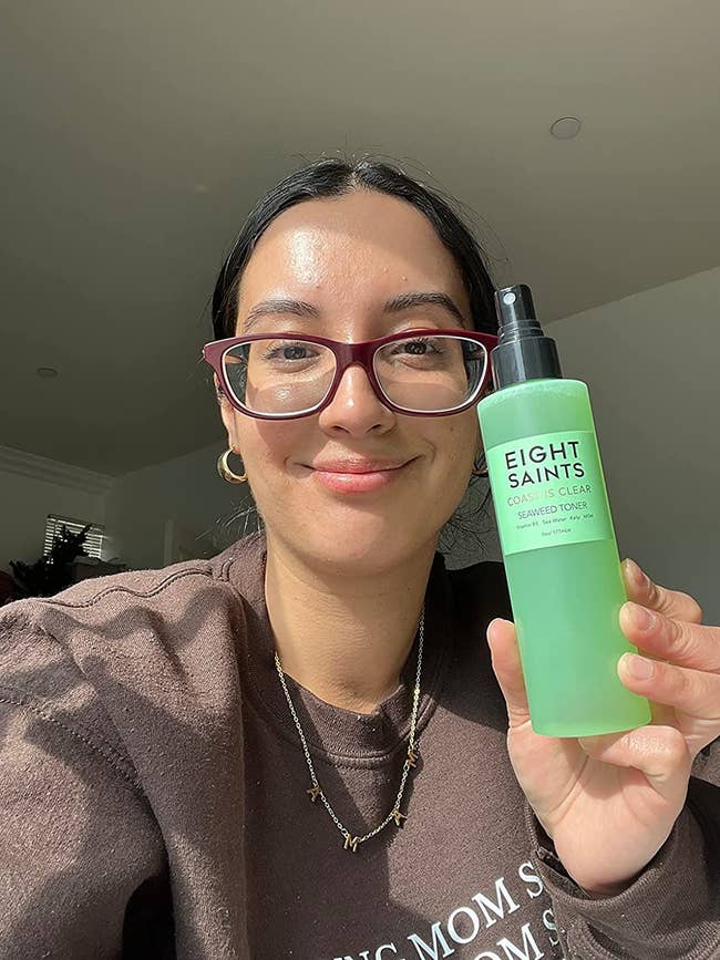 image of reviewer with clear skin holding the toner