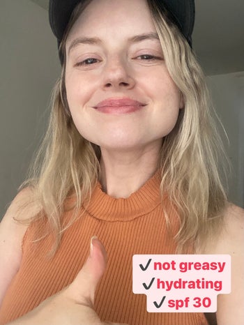 BuzzFeed editor with their CeraVe moisturizer applied and giving a thumbs up, with text 