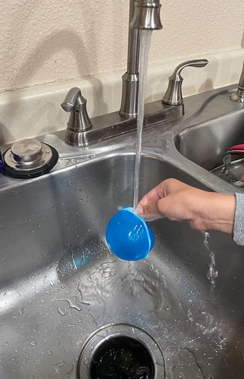 a reviewer fills up a blue balloon