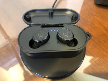 Wireless earbuds successful  a charging case, placed connected  a shiny surface
