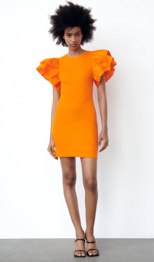 Model wearing orange dress