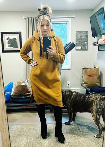 a reviewer wearing the same hooded dress in mustard yellow 