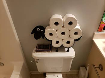 same toilet paper holder on top of white toilet