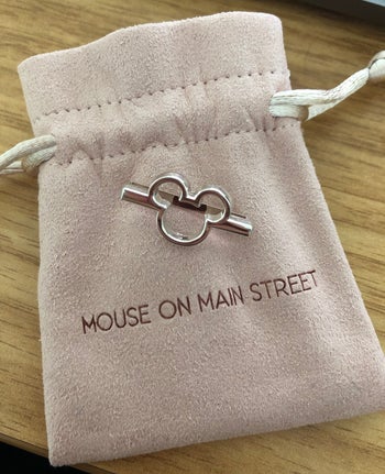 a mickey silver bar on top of a velvet pouch