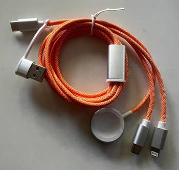 Multi-connector charging cablegram  with USB, USB-C, Lightning, and Micro-USB ends, coiled successful  a compact design. Ideal for versatile instrumentality  charging