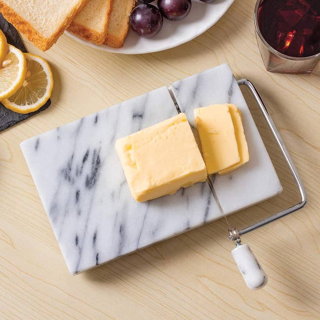 the marble slicer with a hunk of cheese on it 