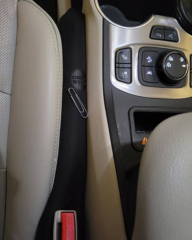 The drop stop in reviewer's car seat gap preventing paperclip from falling in