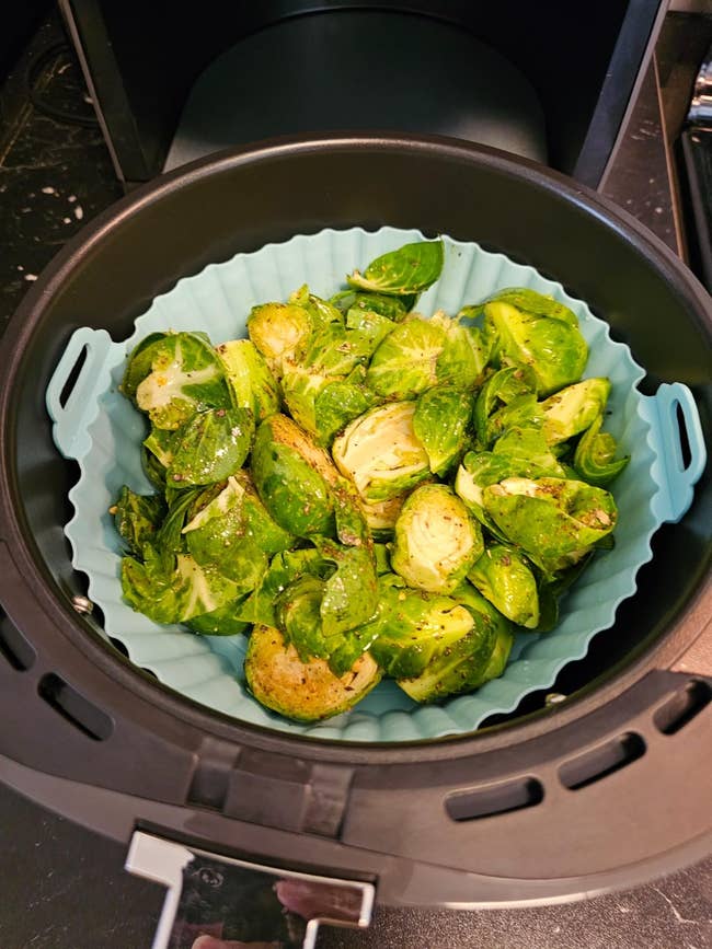 Brussels sprouts seasoned and placed successful  a silicone liner wrong  an aerial  fryer basket