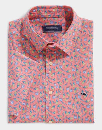 closeup of a coral pink button down collared shirt with pineapples and mini drinks on it