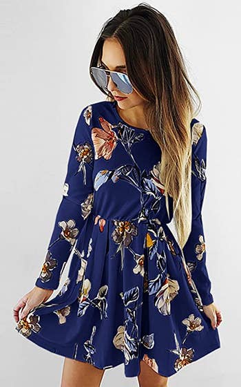 a model wearing the dress in navy blue with florals on it
