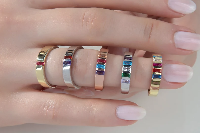 Model showing five birthstone rings in gold, rose gold, silver, and various gemstones