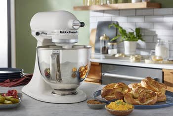 KitchenAid basal mixer connected a room antagonistic with brushed pretzels and condiments beside it