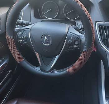 a reviewer photo of the installed steering wheel cover with brown mesh detailing 