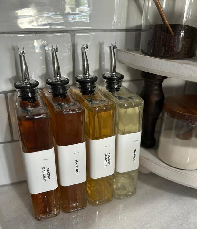 reviewer's our glass bottles of syrup with labels reading Salted Caramel, Hazelnut, French Vanilla, and Vanilla