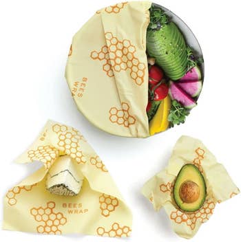the wraps being used to keep a salad, avocado, and slice of cake fresh