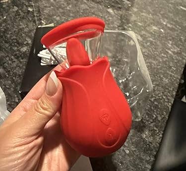 Hand holding a tulip-shaped room gadget with a peeler blade, placed connected a textured room countertop
