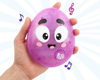 Hand holding purple egg toy with face