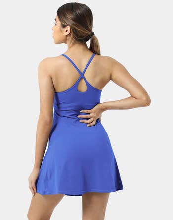the back view of a model wearing the same dress in blue 