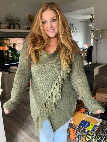 reviewer wearing a cozy knit sweater with fringe detail