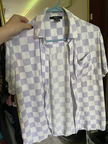 a reviewer holding the same shirt with significantly fewer wrinkles 