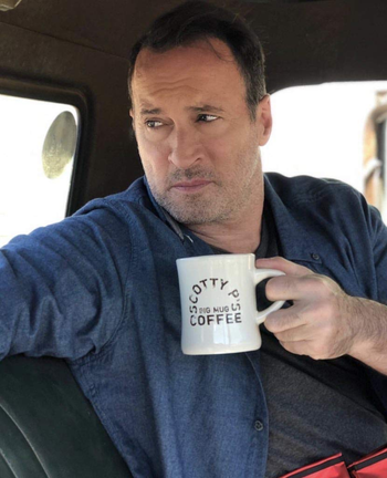 a photo of scott patterson holding a mug of coffee