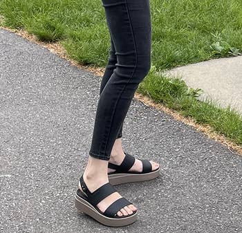 reviewer wearing the black/mushroom sandals
